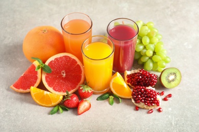 Glasses of different juices and fresh fruits on table