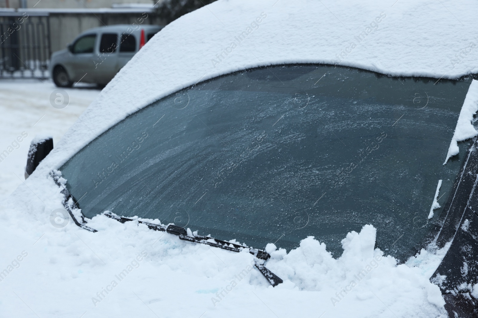 Photo of Car windshield with wiper blades cleaned from snow outdoors on winter day