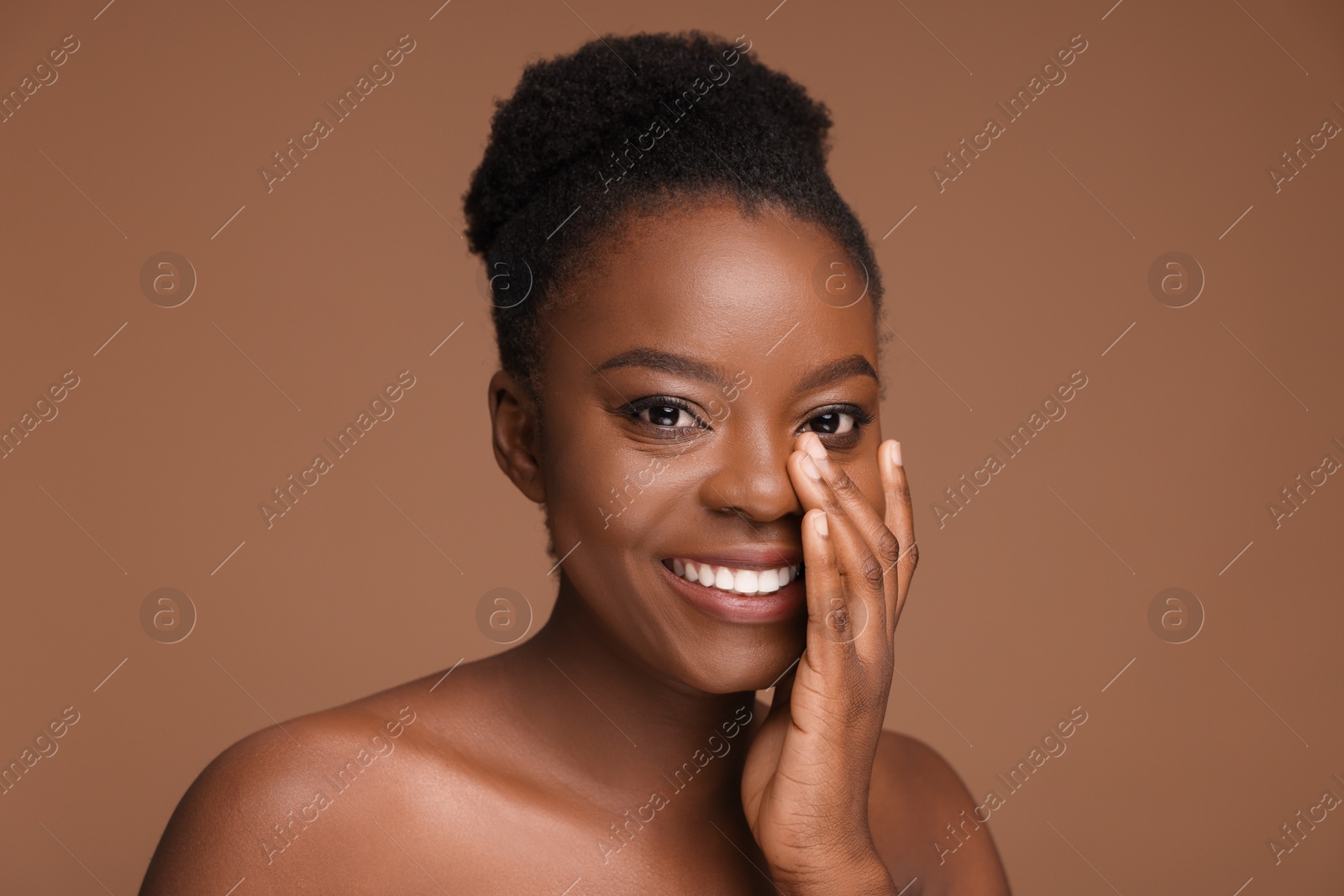 Photo of Portrait of beautiful happy woman on light brown background