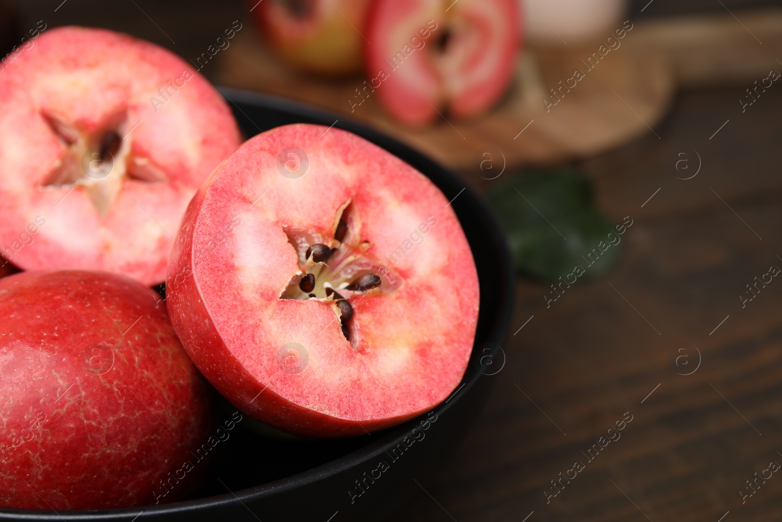 Photo of Tasty apples with red pulp on wooden table, closeup. Space for text