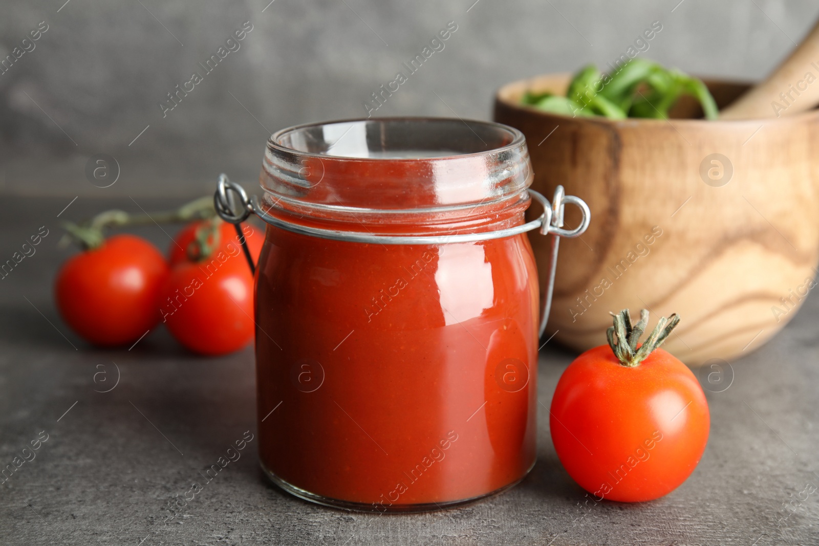 Photo of Composition with tomato sauce in jar on table