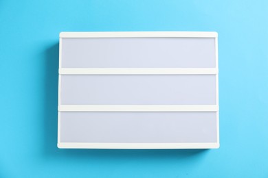 Photo of Blank letter board on light blue background, top view