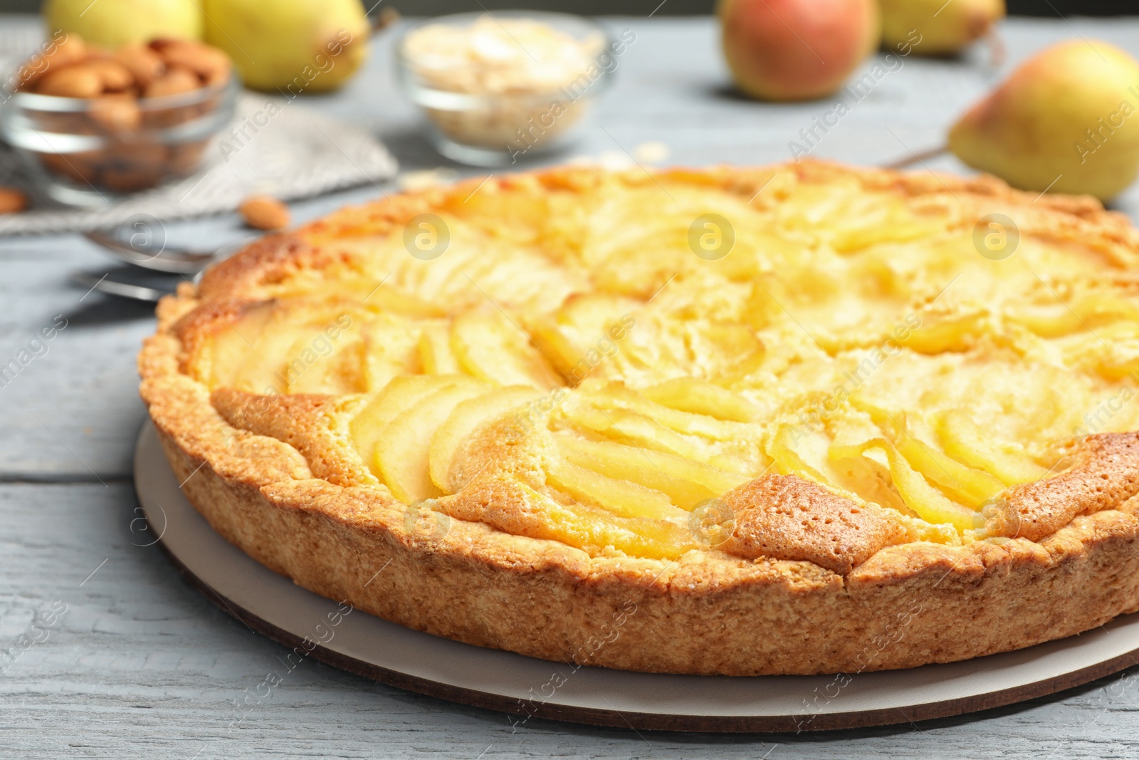 Photo of Delicious sweet pear tart on grey wooden table, closeup