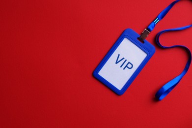 Photo of Plastic vip badge on red background, top view. Space for text