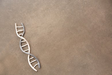 DNA molecule model made of colorful plasticine on brown background, top view. Space for text