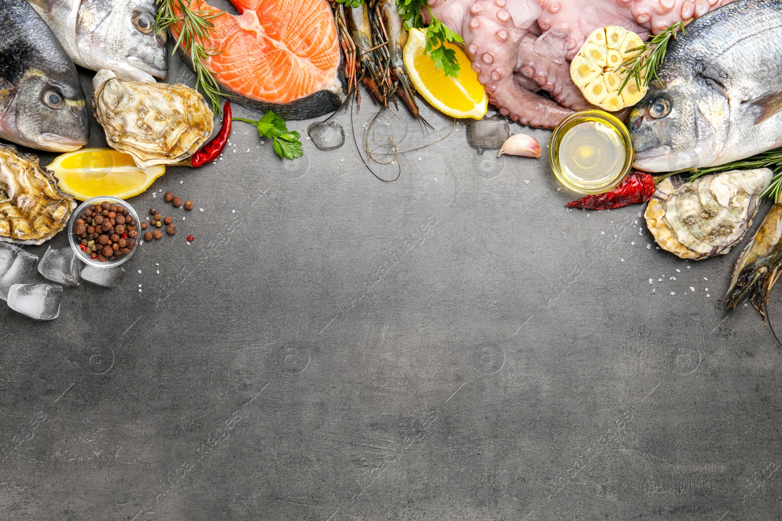 Photo of Flat lay composition with fresh raw dorado fish and different seafood on grey table. Space for text