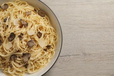 Tasty spaghetti with truffle on wooden table, top view. Space for text