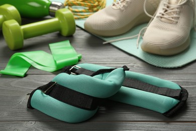 Photo of Turquoise weighting agents and sport equipment on grey wooden table