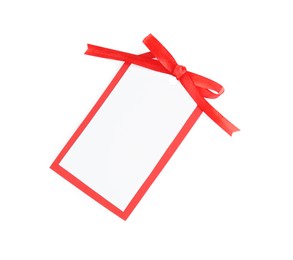 Blank gift tag with red satin ribbon on white background, top view