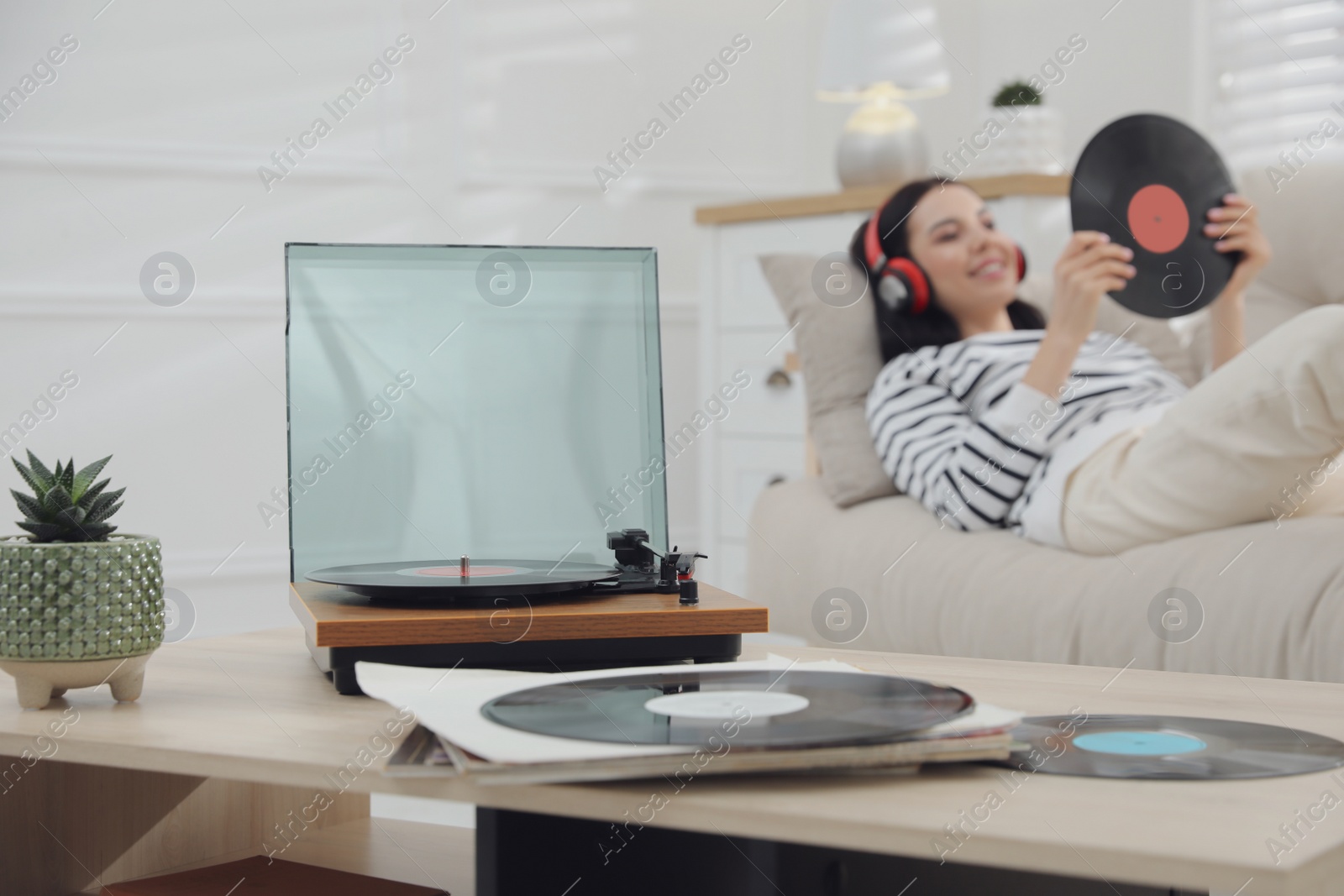 Photo of Woman listening to music with turntable in living room