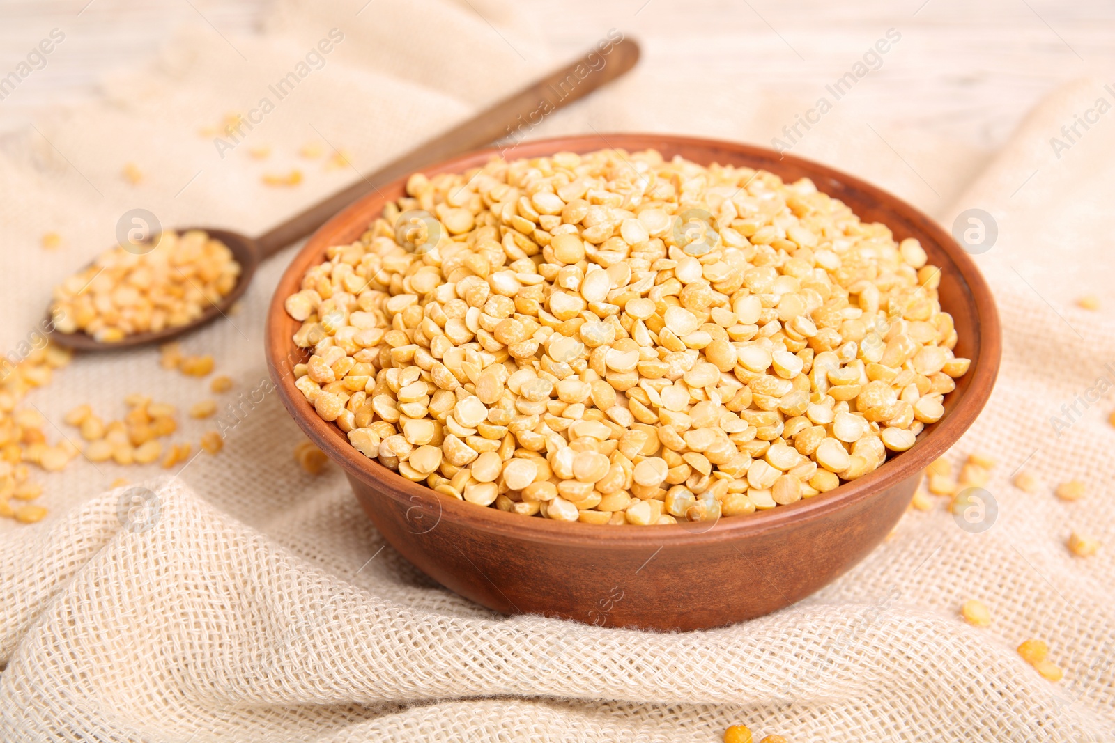 Photo of Bowl and spoon with dried peas on fabric