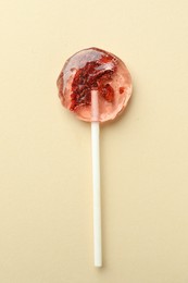 Photo of Sweet colorful lollipop with berries on beige background, top view