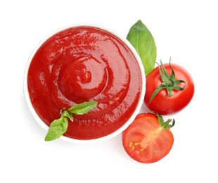 Photo of Tasty ketchup in bowl, basil and fresh tomatoes isolated on white, top view