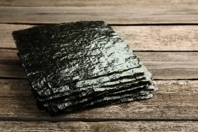 Photo of Stack of dry nori sheets on wooden table