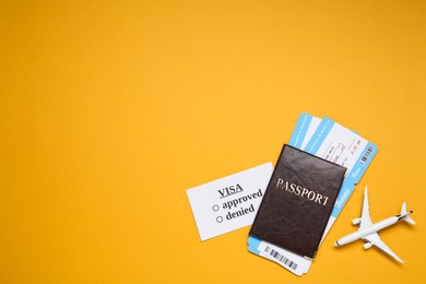 Photo of Flat lay composition with passport, toy plane and tickets on orange background, space for text. Visa receiving