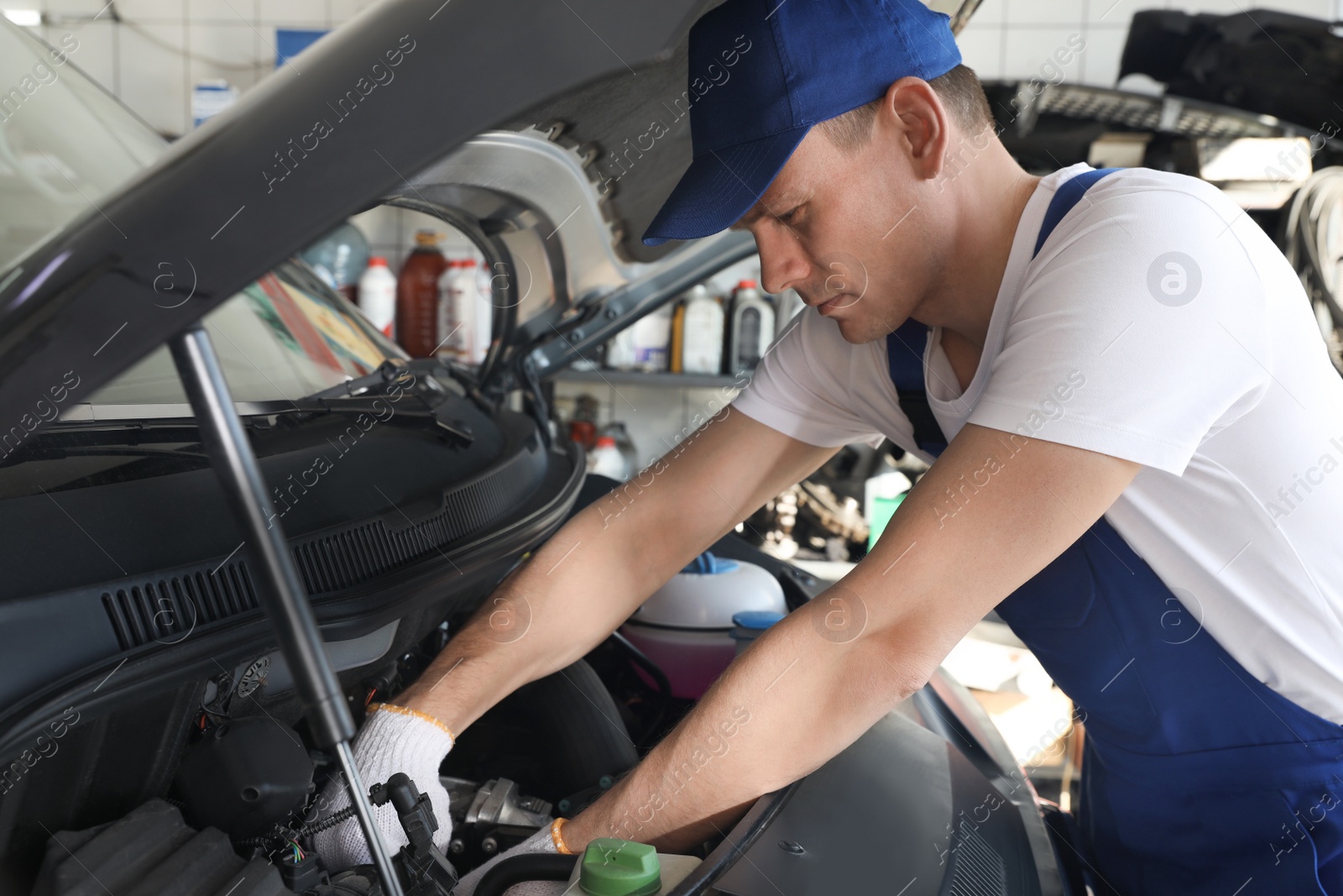 Photo of Professional auto mechanic fixing modern car in service center