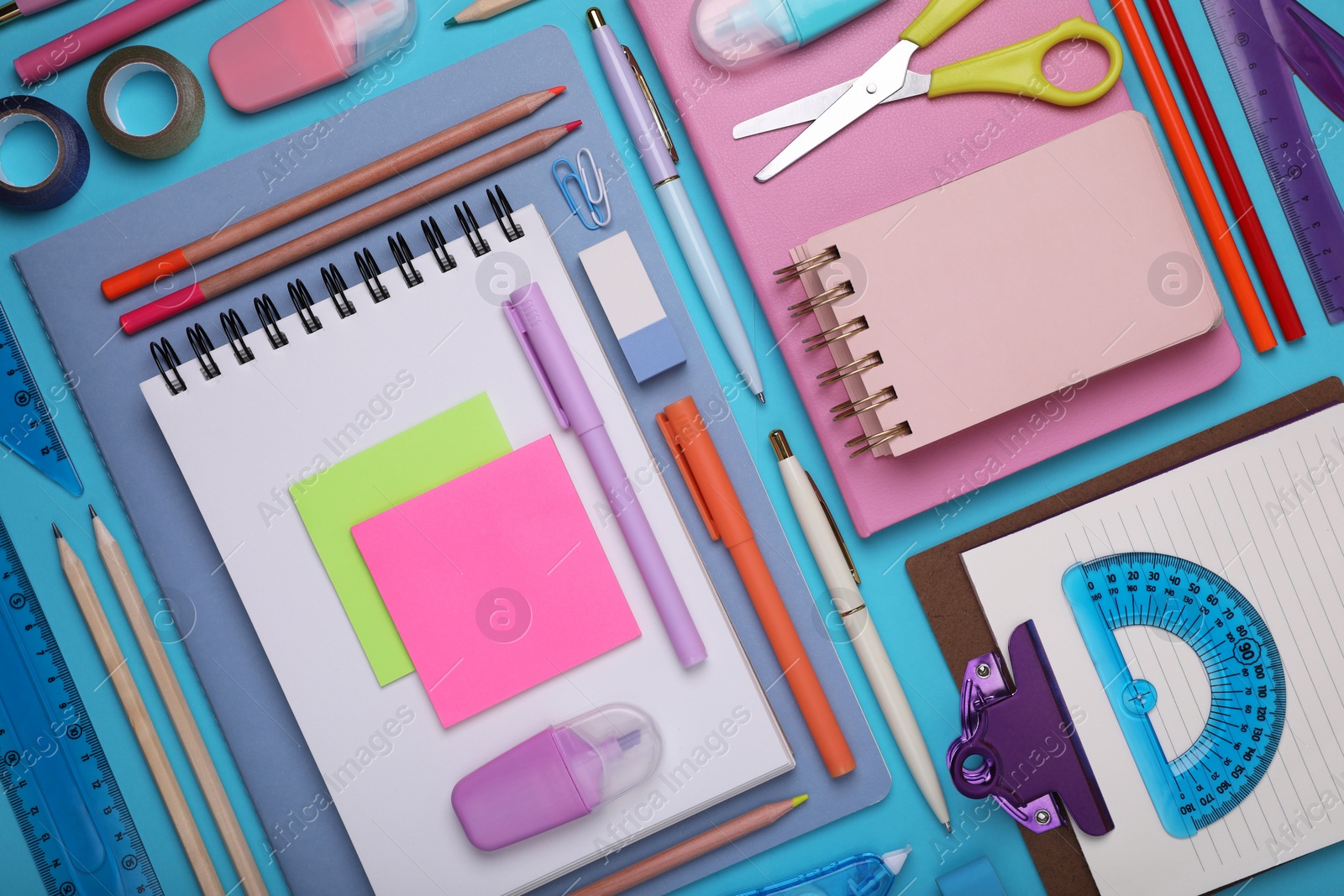 Photo of Flat lay composition with notebooks and other school stationery on light blue background. Back to school