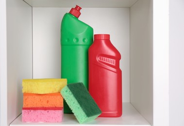 Photo of Different cleaning supplies and sponges on shelf