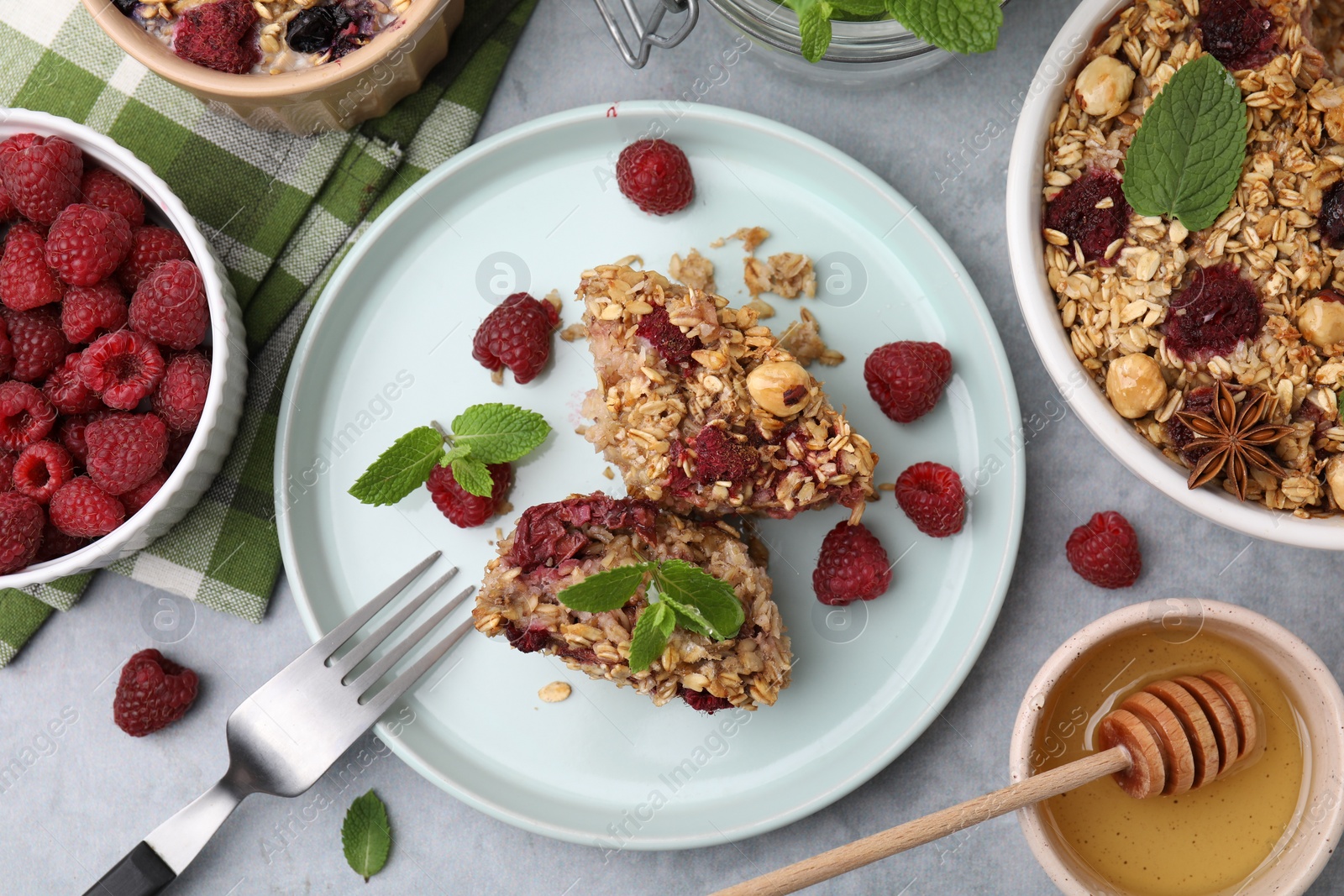 Photo of Tasty baked oatmeal with berries served on light grey table, flat lay