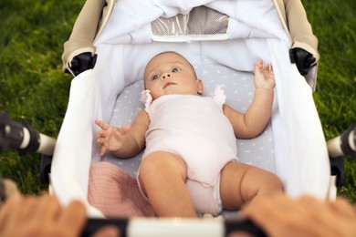 Photo of Mother with baby in stroller outdoors, closeup