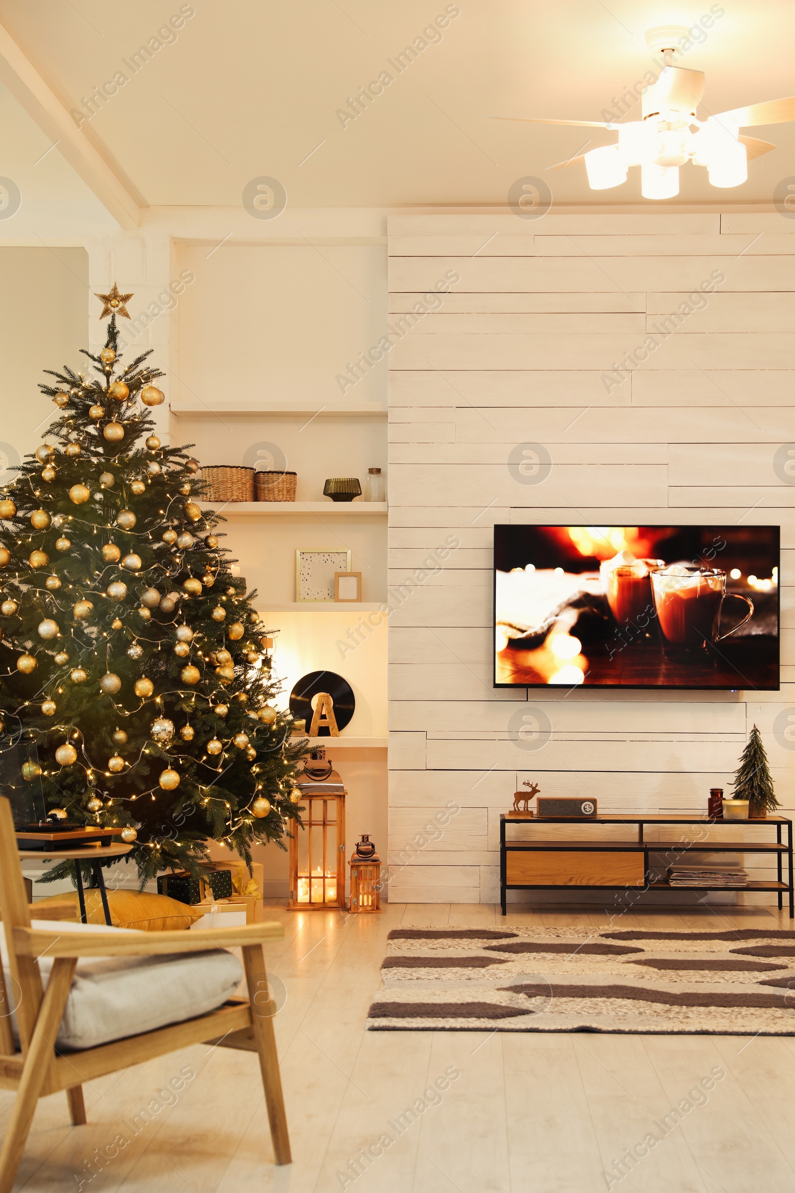 Photo of Plasma TV on white wooden wall in living room beautifully decorated for Christmas