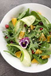 Photo of Delicious salad with cucumber and orange slices on gray table, top view