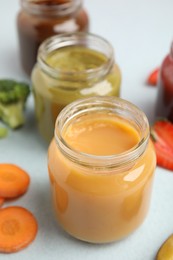 Healthy baby food and carrot on grey background