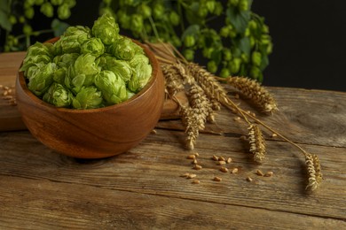 Fresh green hops, wheat grains and spikes on wooden table