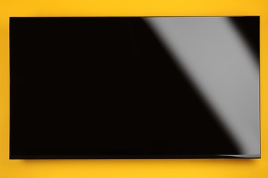 Modern TV with blank wide screen on orange background
