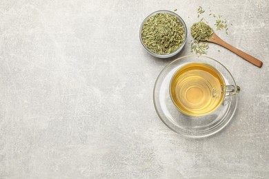 Photo of Aromatic fennel tea and seeds on light grey table, flat lay. Space for text