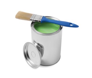 Photo of Can of light green paint and brush on white background