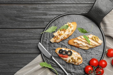 Photo of Slate plate of delicious chicken bruschettas on dark wooden table, flat lay. Space for text