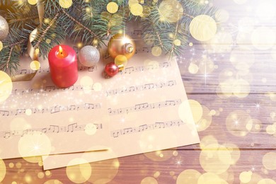 Composition with Christmas decorations and music sheets on wooden table. Bokeh effect