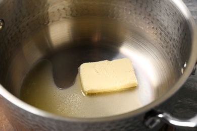 Piece of melting butter in pot, closeup
