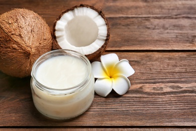 Photo of Beautiful composition with coconut oil and nuts on wooden background