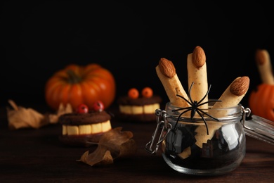 Delicious desserts decorated as monster fingers on wooden table. Halloween treat