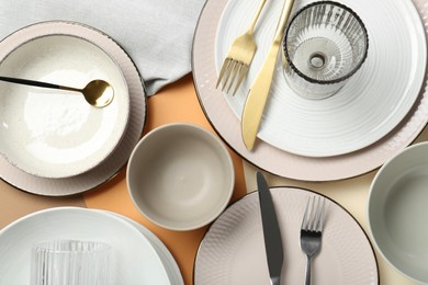 Photo of Clean plates, bowls, glasses and cutlery on table, flat lay
