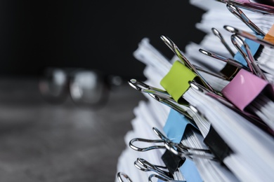 Photo of Stack of documents with binder clips on table, closeup view. Space for text