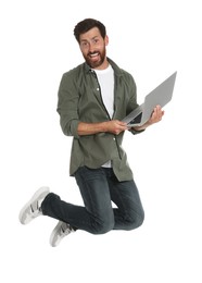 Photo of Happy man with laptop jumping on white background