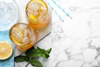 Photo of Delicious iced tea on white marble table, flat lay. Space for text