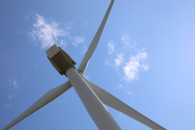 Wind turbine against beautiful blue sky, low angle view. Alternative energy source