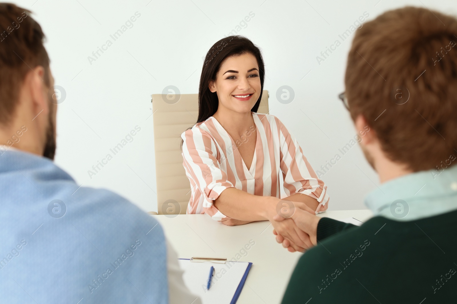 Photo of Human resources manager shaking hands with applicant during job interview in office