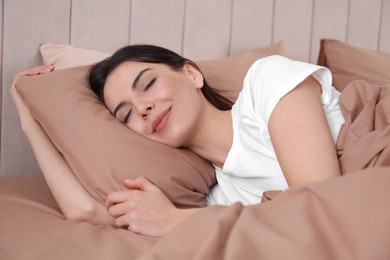 Photo of Woman sleeping in comfortable bed with beige linens