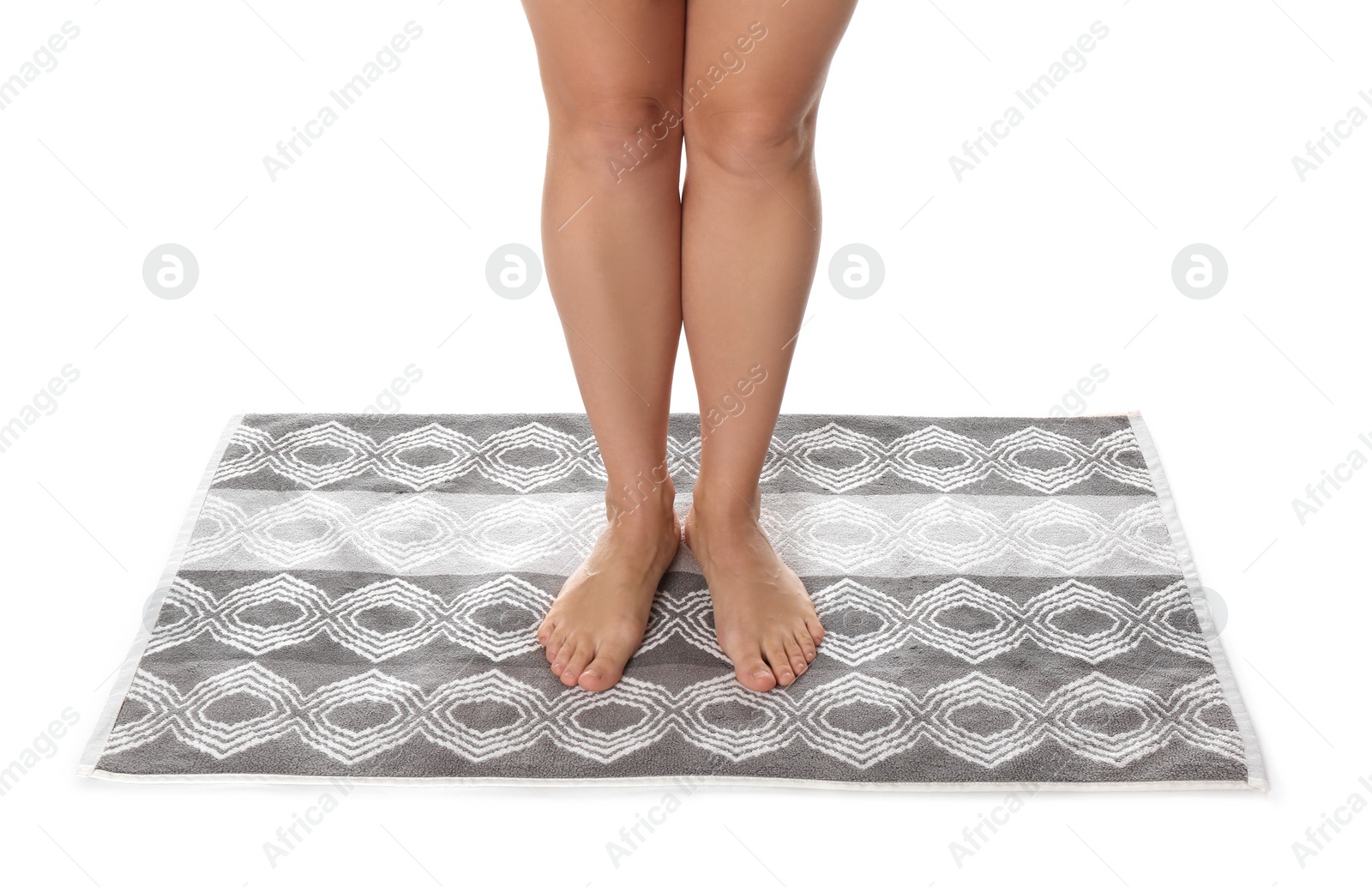 Photo of Woman standing on stylish bath mat against white background, closeup