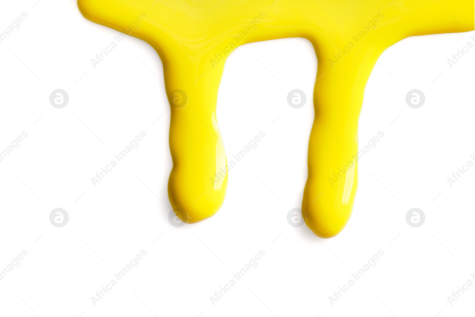 Photo of Yellow nail polish flowing on white background