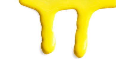 Photo of Yellow nail polish flowing on white background