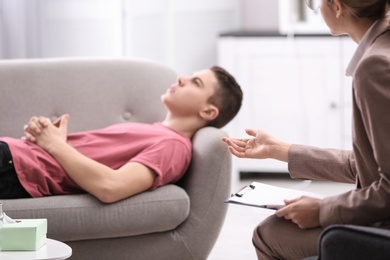 Photo of Psychotherapist working with young man in office, closeup