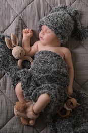 Photo of Cute newborn baby sleeping with toys in bed, top view