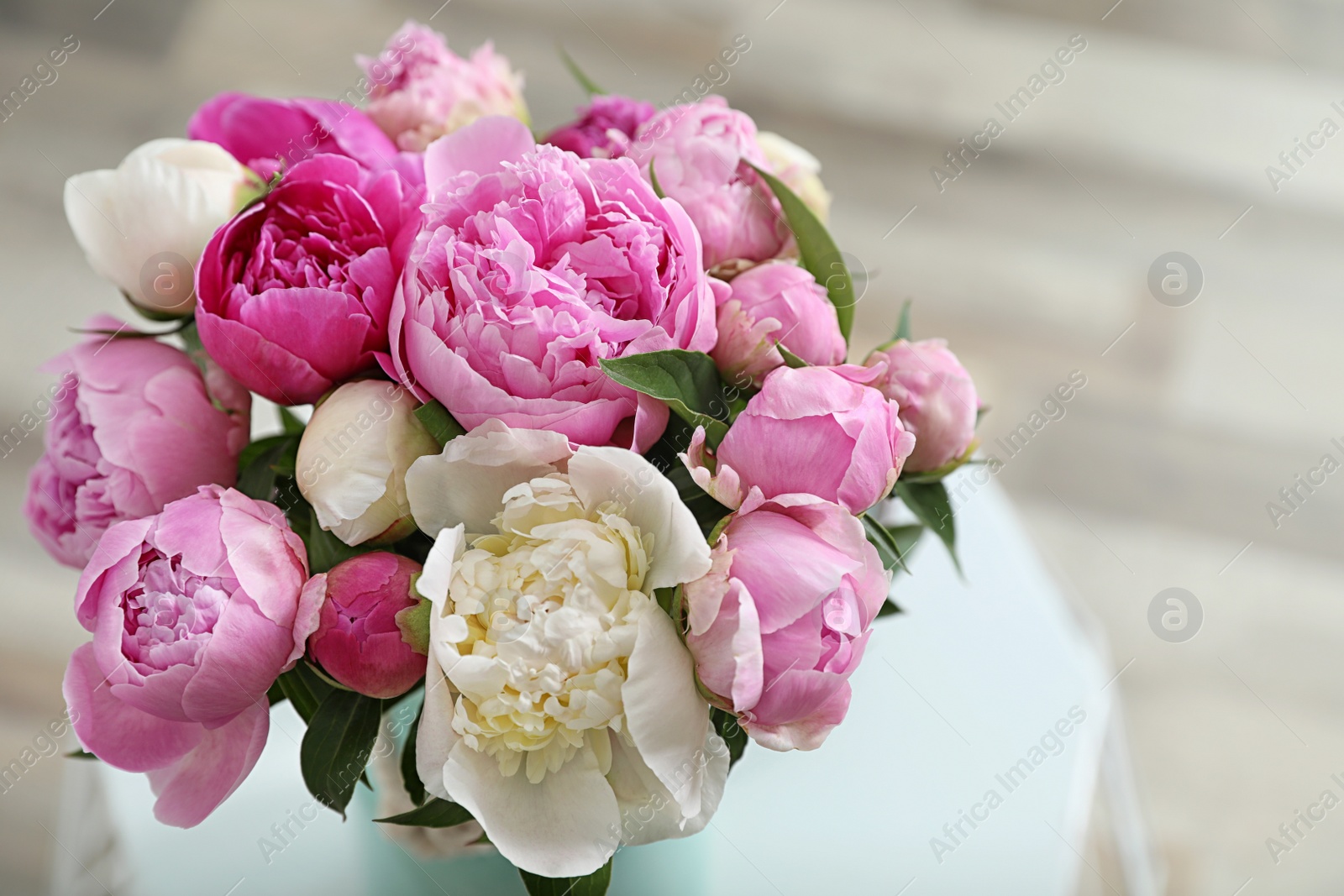 Photo of Vase with bouquet of beautiful peonies on table in room, above view. Space for text