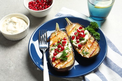 Photo of Plate with tasty fried eggplants on gray table